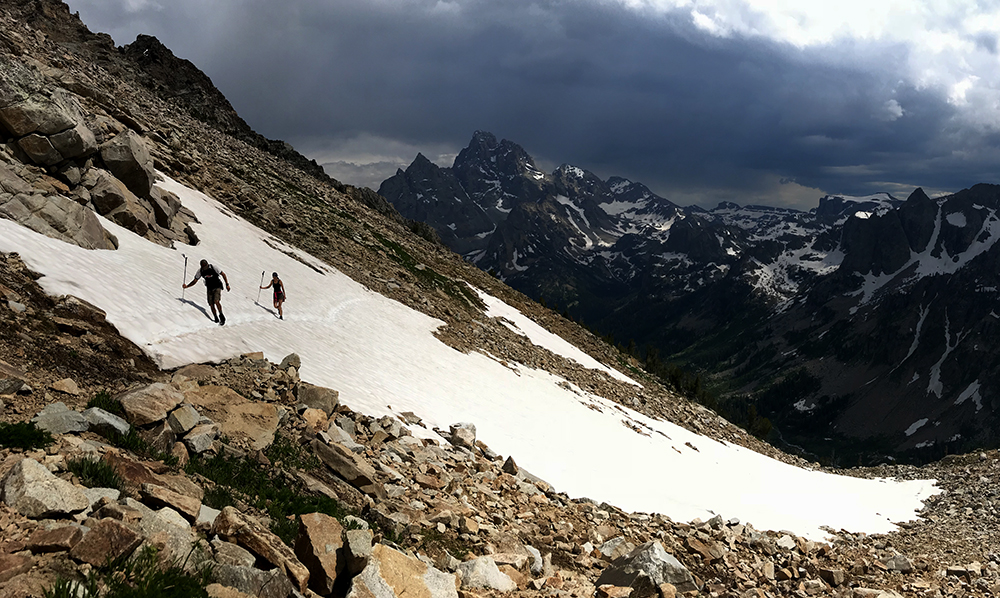 hikers crossing snowfield in grand teton national park