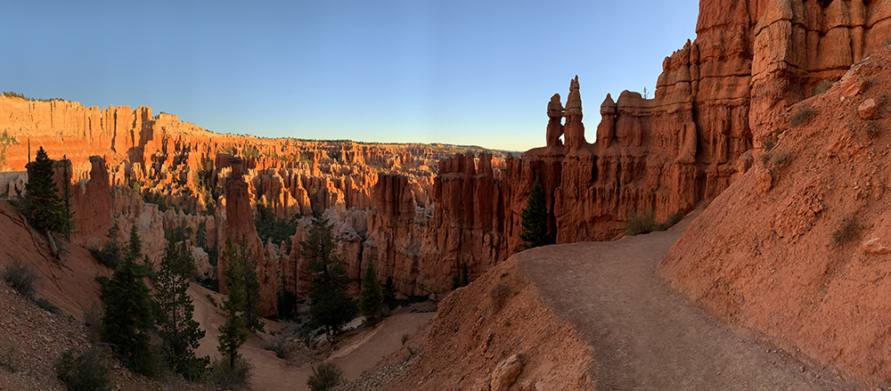 a trail descends into a world of red hoodoos