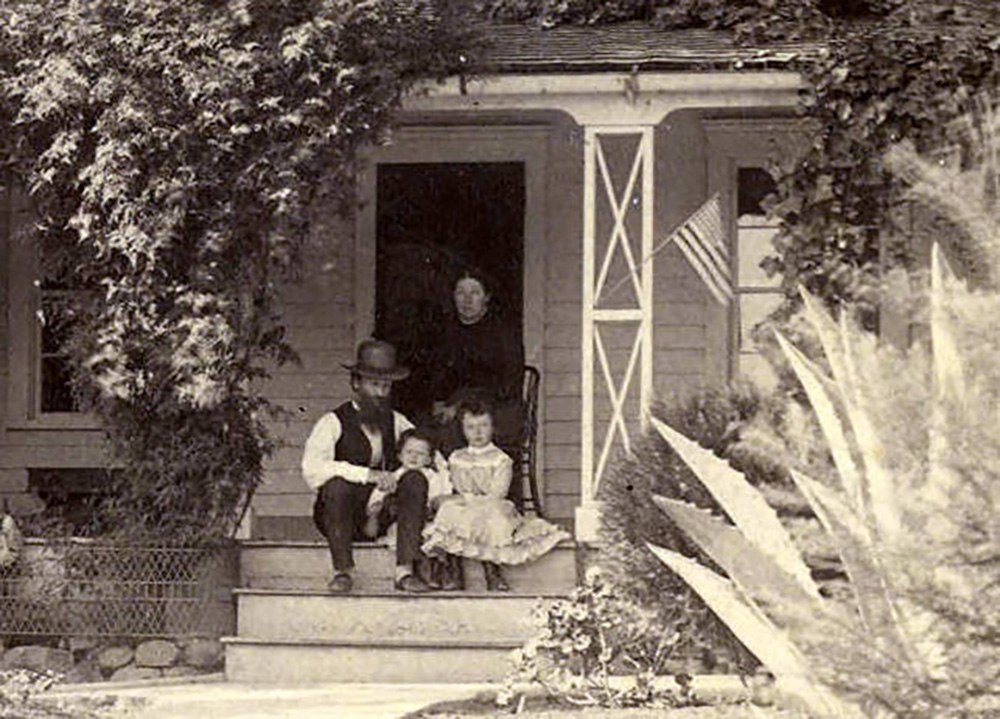 Muir with family on porch of home